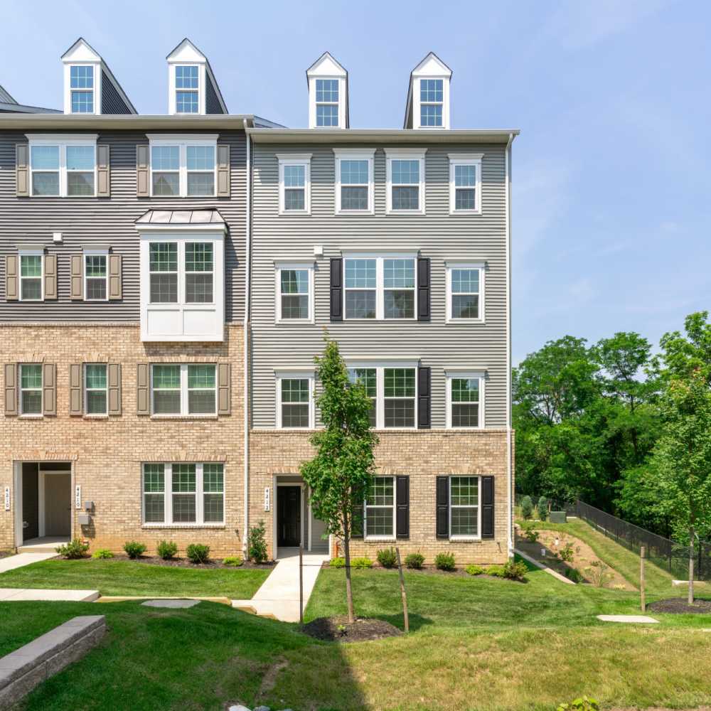 Apartment complex exterior featuring a lawn and trees, located at Dorsey Overlook in Ellicott City, Maryland.