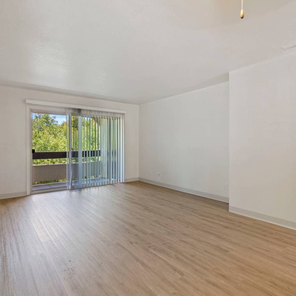 Living room with sliding glass doors to private balcony at Mission Gardens in Santa Cruz, California