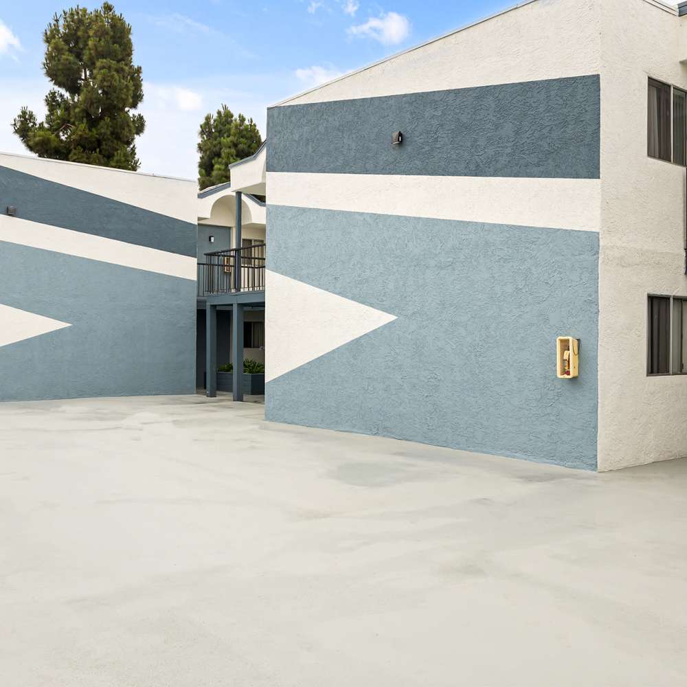 An apartment building featuring stairs and a blue and white wall, showcasing modern architectural design at Mar at Grove in Imperial Beach, California