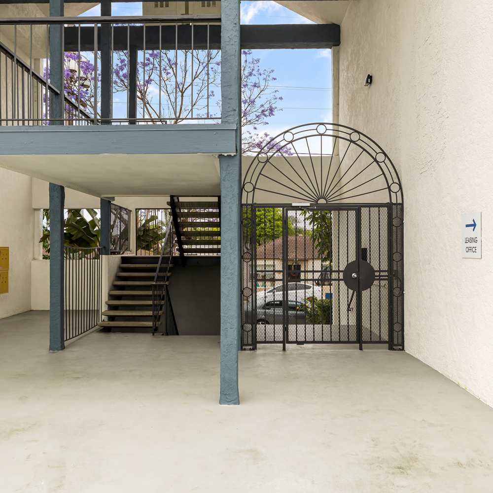 An apartment building featuring a stairway and a gated entrance at Mar at Grove in Imperial Beach, California
