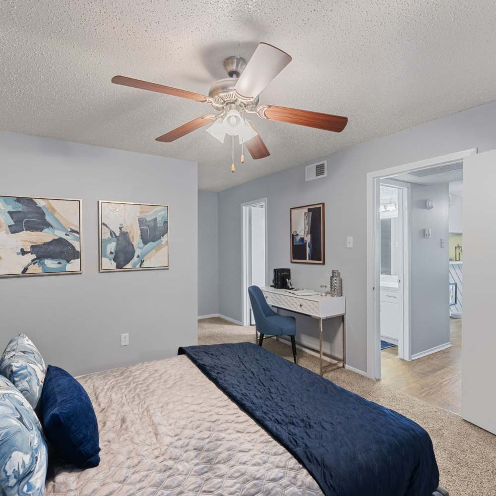 Cozy bedroom from a different angle that showcases the doors going to different rooms at The Madeleine in Fort Worth, Texas