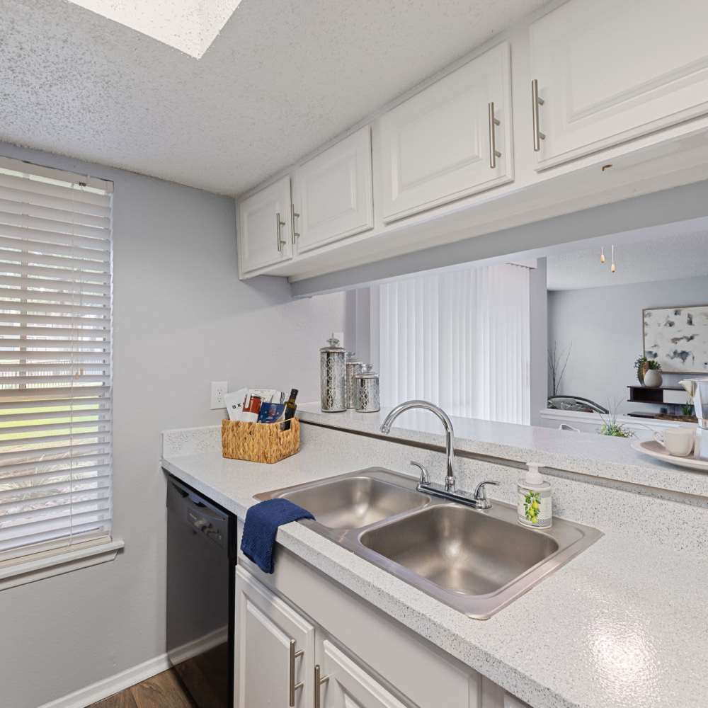 Kitchen area that showcases the sink and hanging cabinets at The Madeleine in Fort Worth, Texas