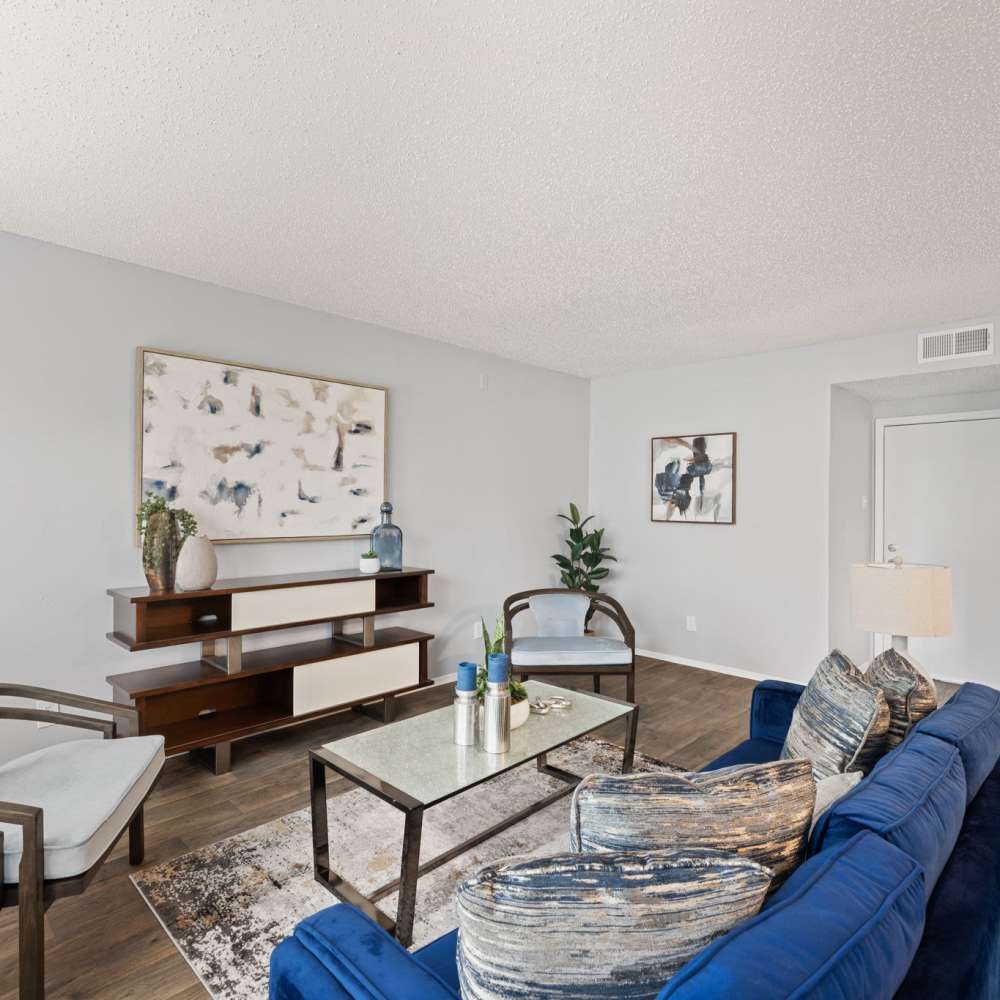 Furnished living room with blue couch and center table at The Madeleine in Fort Worth, Texas