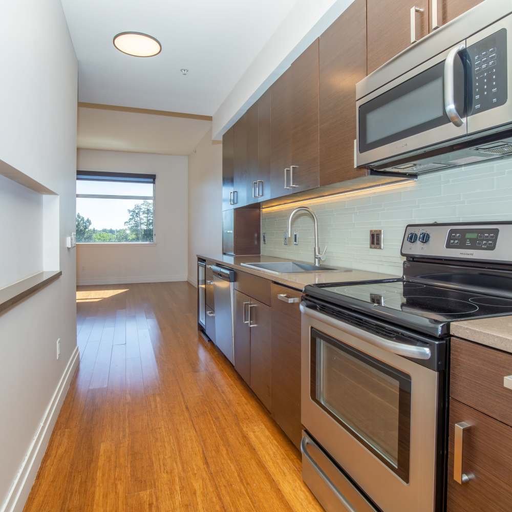 Kitchen with wooden cabinets and stainless-steel appliances at The View at Wash Park in Denver, Colorado