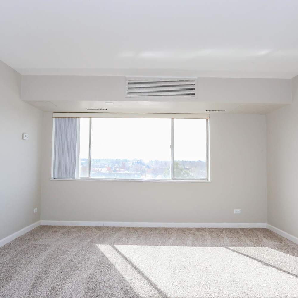 Bright bedroom with a window and AC at Wellshire Apartments in Denver,Colorado