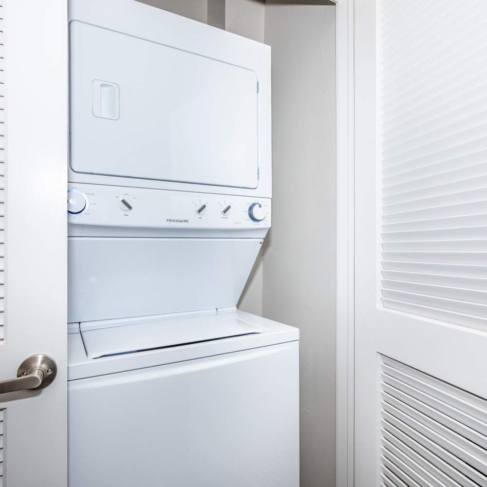In-home stackable washer and dryer unit at Park Place Olde Town Apartments in Arvada, Colorado