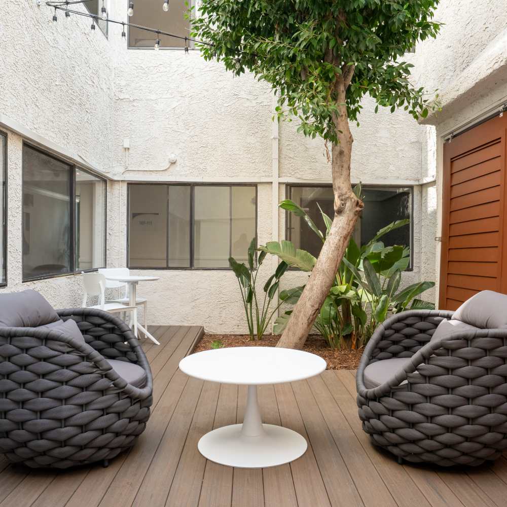 Modern courtyard with two woven lounge chairs at Canyon Village in North Hollywood, California