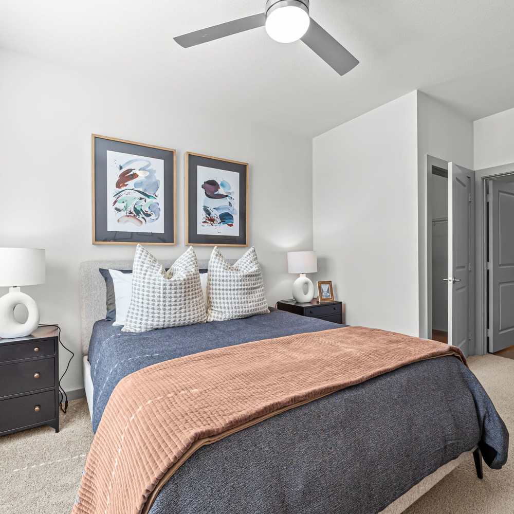 Bedroom with a ceiling fan and bright interiors at Main and Mill in Lewisville,Texas