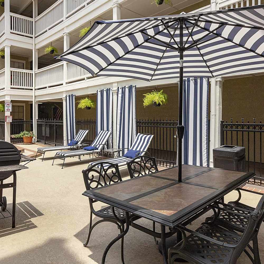 Seating with umbrella at Lincoln Court Apartments in Dallas, Texas