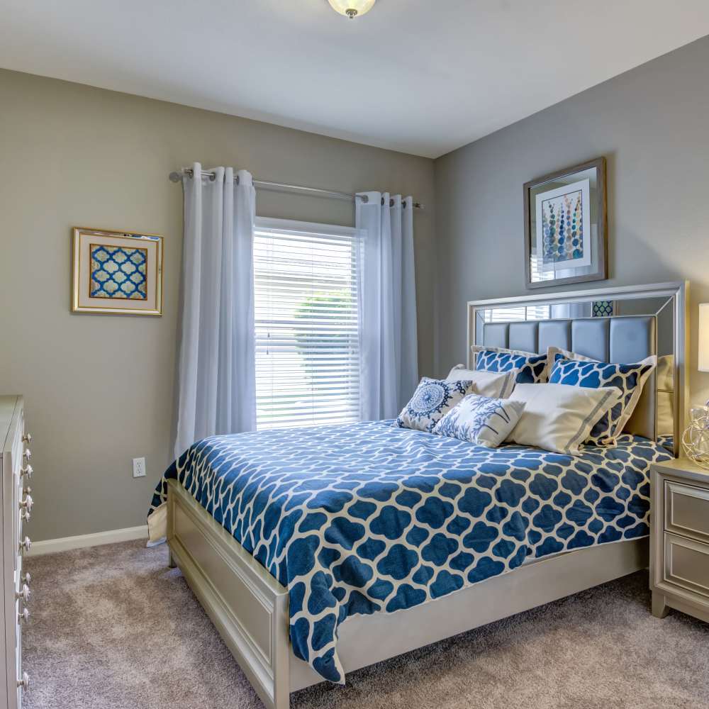 Well-lit bedroom with a large window at Northland Heights in Kansas City, Missouri