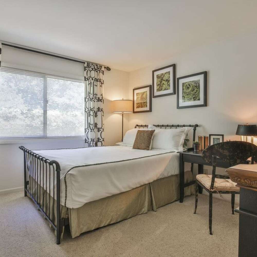 Cozy bedroom with stylish decor and sunny window view at Avonlea Riverside in Atlanta, Georgia