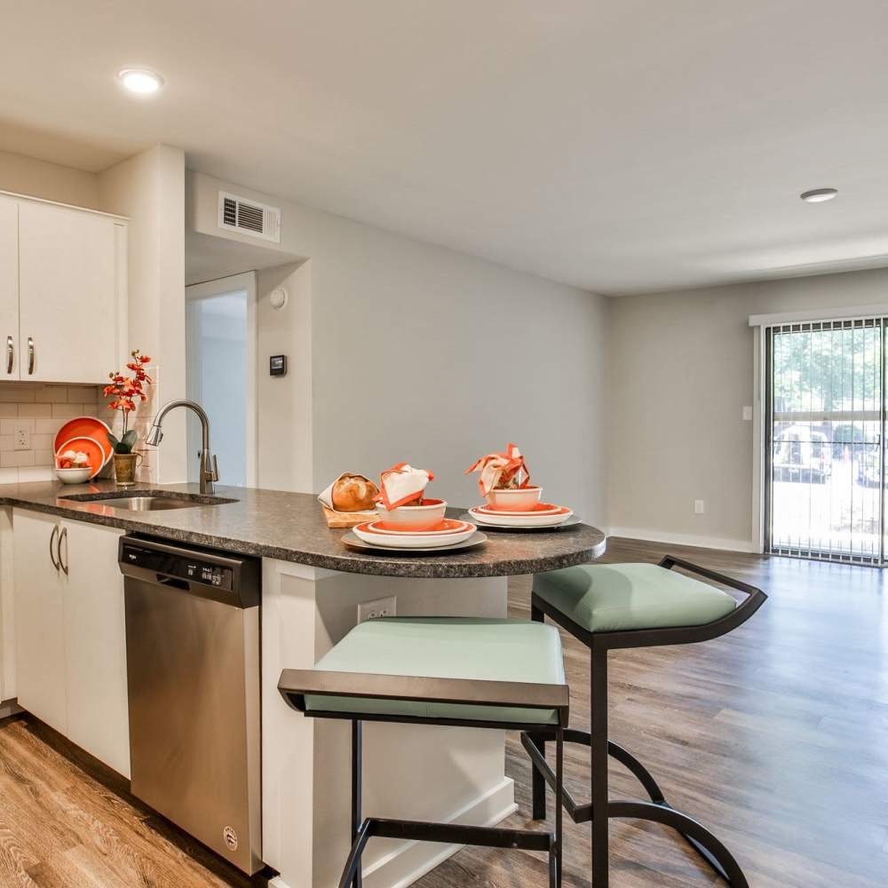 Modern kitchen with stylish bar seating and vibrant table settings at Avonlea Riverside in Atlanta, Georgia