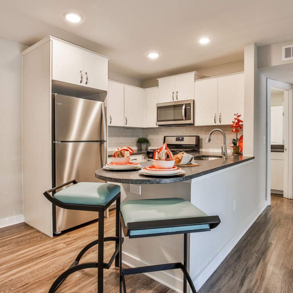 Modern kitchen with sleek appliances and stylish dining setup at Avonlea Riverside in Atlanta, Georgia
