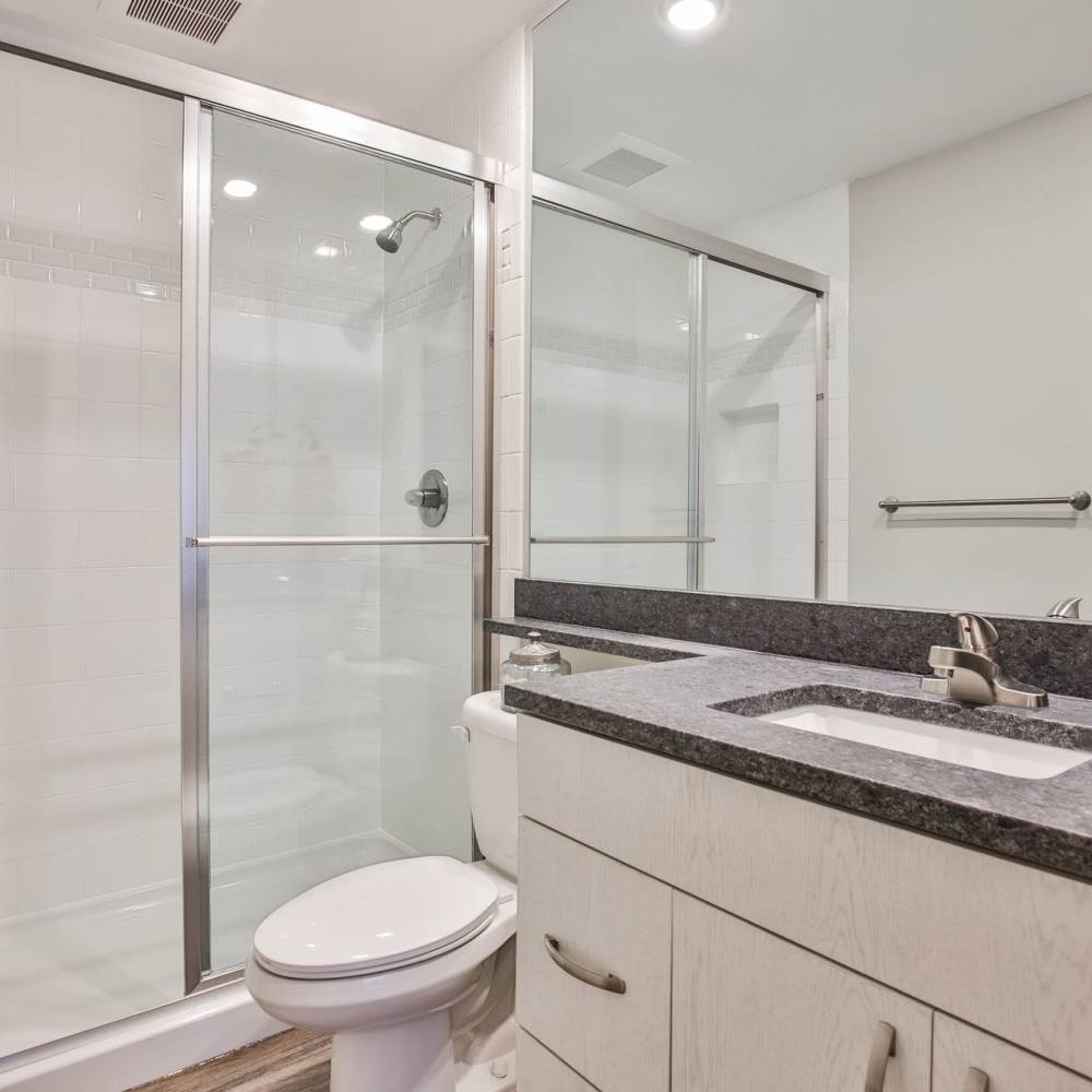 Sleek bathroom with glass shower and modern countertop fixtures at Avonlea Riverside in Atlanta, Georgia