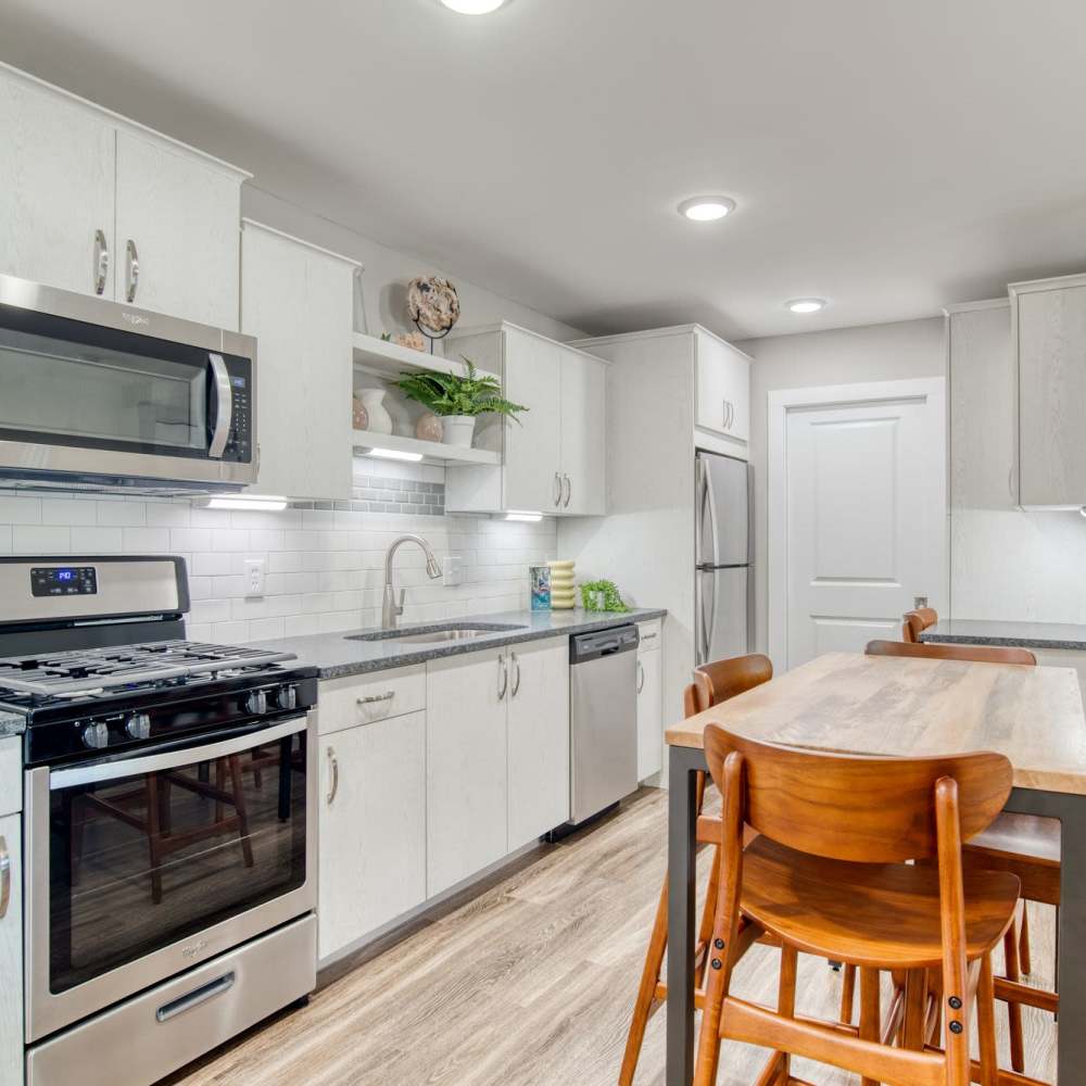 Modern kitchen with stainless steel appliances and wooden dining table at Avonlea Riverside in Atlanta, Georgia
