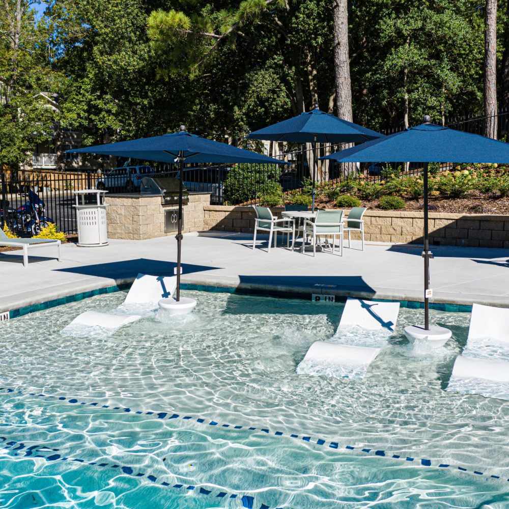 Sparkling pool with lounge chairs and shaded seating area at Avonlea Riverside in Atlanta, Georgia