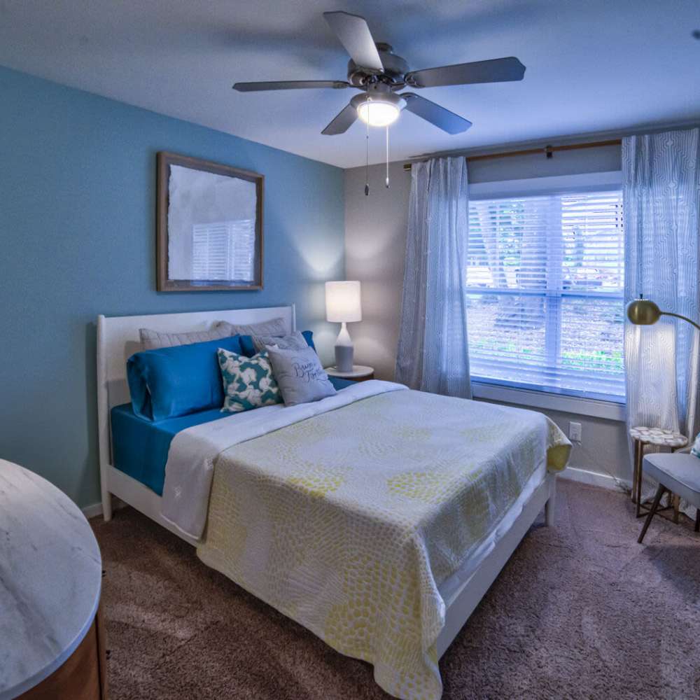 Cozy bedroom with light blue walls and natural light at Avonlea Riverside in Atlanta, Georgia