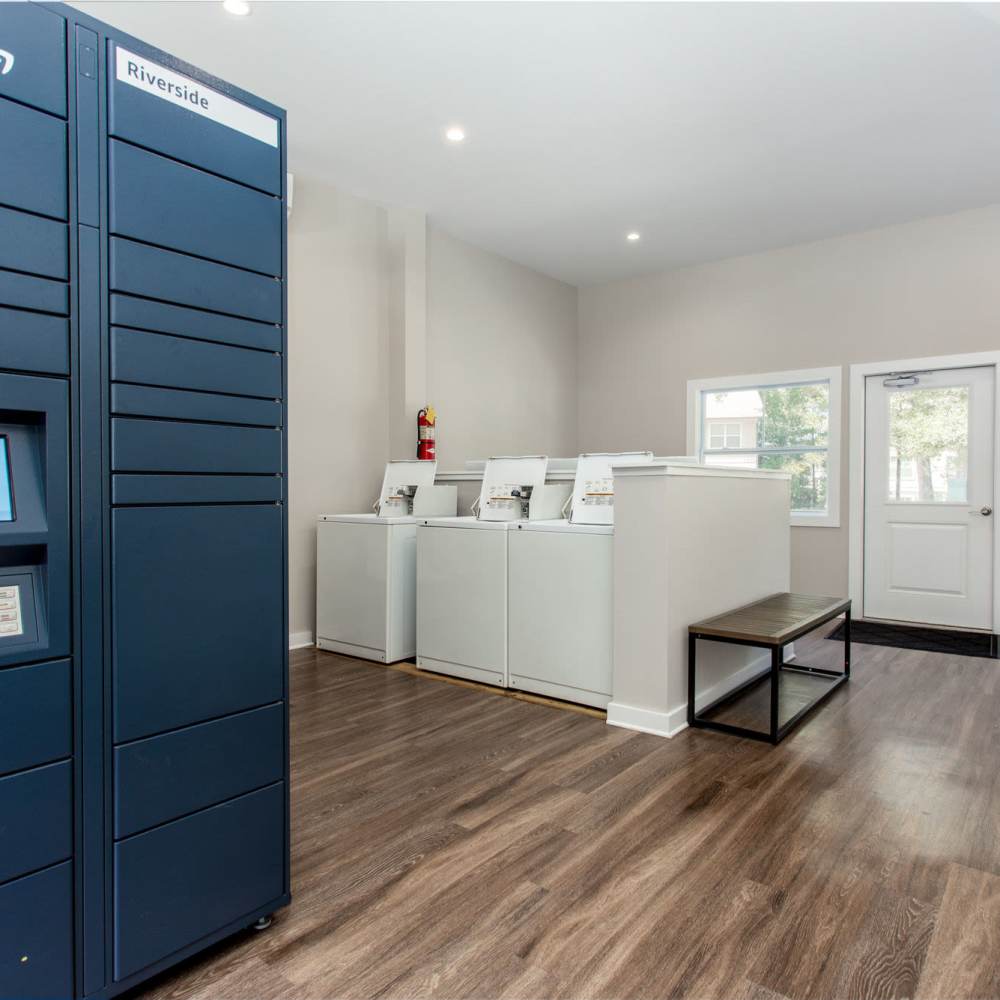 Bright laundry room with modern appliances and organized storage unit at Avonlea Riverside in Atlanta, Georgia