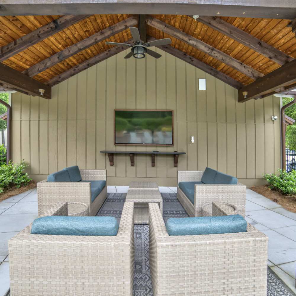 Cozy outdoor lounge with seating and mounted television at Avonlea Riverside in Atlanta, Georgia