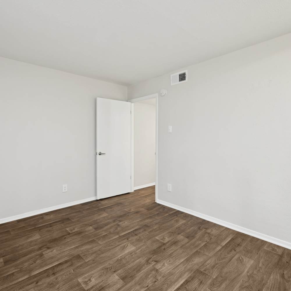 Bright, empty room with modern flooring and fresh paint at Woodlands of Plano in Plano, Texas