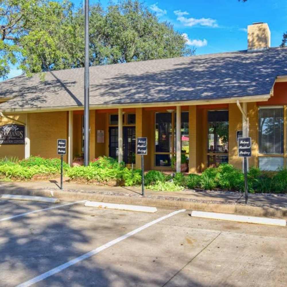 Charming community surrounded by lush greenery and inviting parking at Woodlands of Plano in Plano, Texas