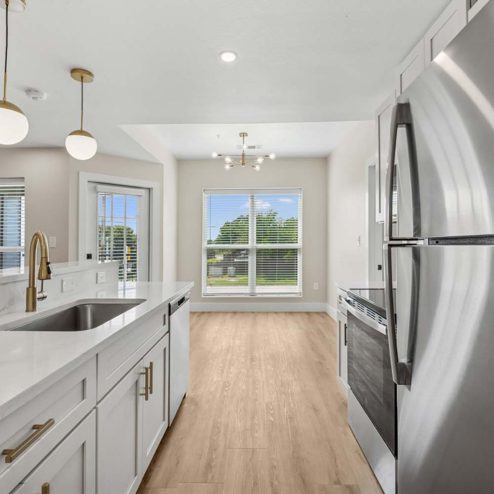 Modern kitchen with wooden cabinets and stainless-steel appliances at Lake Meadows in Garland, Texas