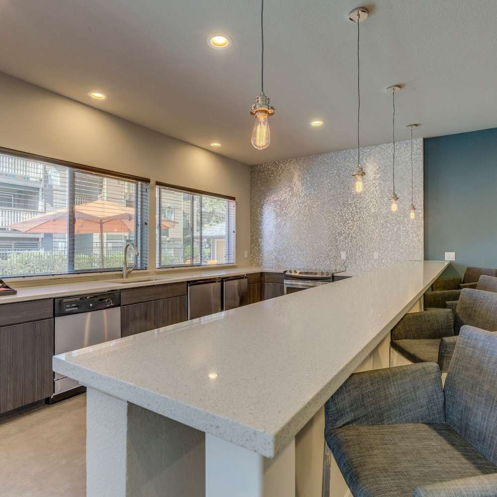 Clubhouse kitchen with quartz counters and bar seating at Plum Tree Park in Renton, Washington