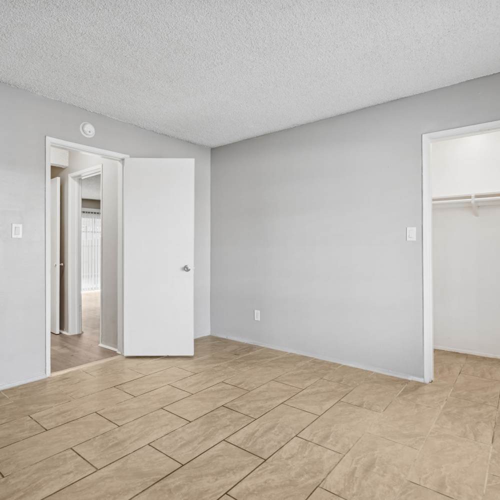 Modern bedroom with attached closet at Newland Garden Apartments in Garden Grove, California
