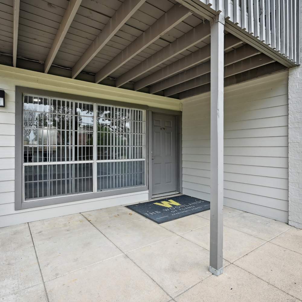 Charming two-story home with inviting balcony and lush greenery at Woodlands of Plano in Plano, Texas