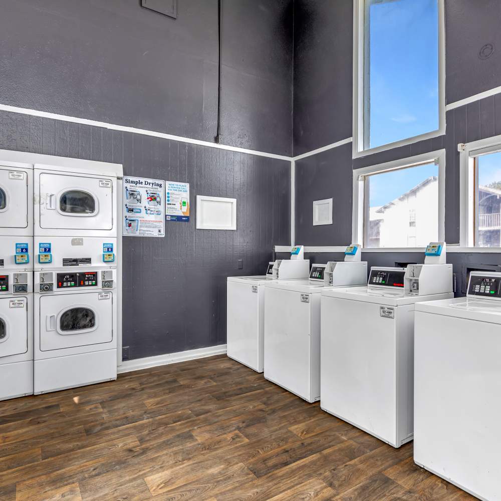 Bright laundry room with modern washers and sleek finishes at Woodlands of Plano in Plano, Texas