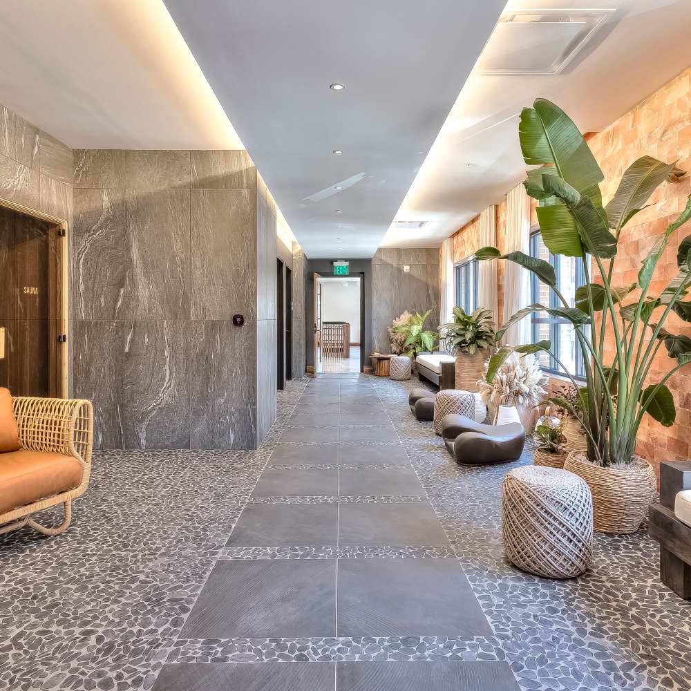 Stylish hallway with modern furnishings and lush indoor plants at Green|House Columbus in Columbus, Ohio