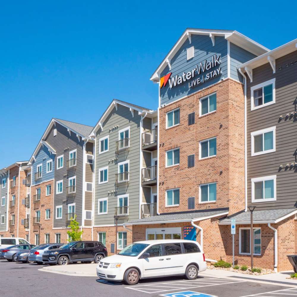 Front entrance sign of community and parking lots at WaterWalk Charlotte - Arrowood in Charlotte, North Carolina