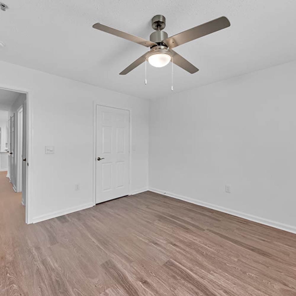 Unfurnished bedroom with wooden flooring and ceiling fan at Osprey Place Apartments in North Charleston, South Carolina