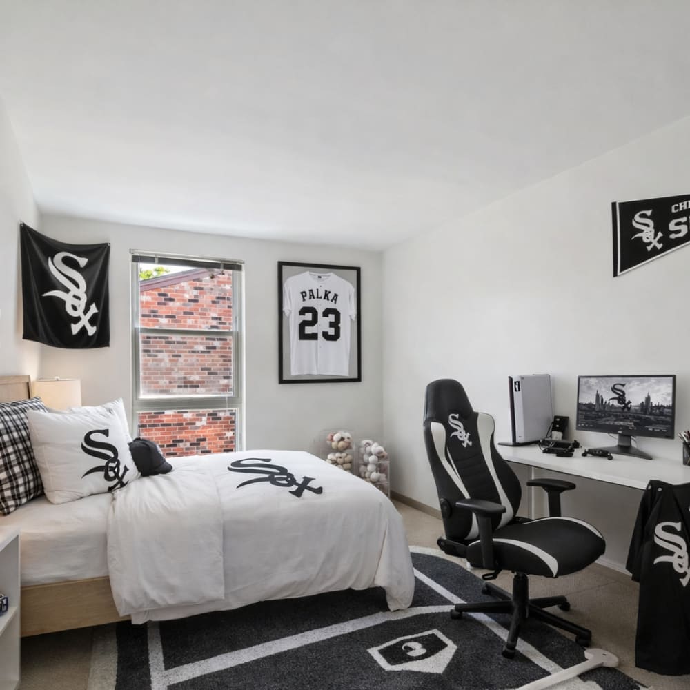 Bedroom staged in chicago white sox with a large window at BJ Wright Court Apartments in Chicago, Illinois