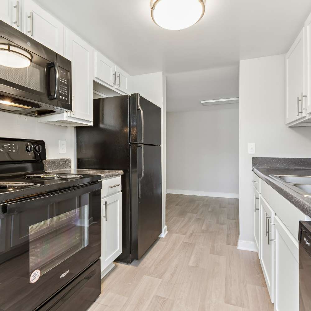 Galley-style kitchen with black appliances at Reserve South in Richmond, Virginia