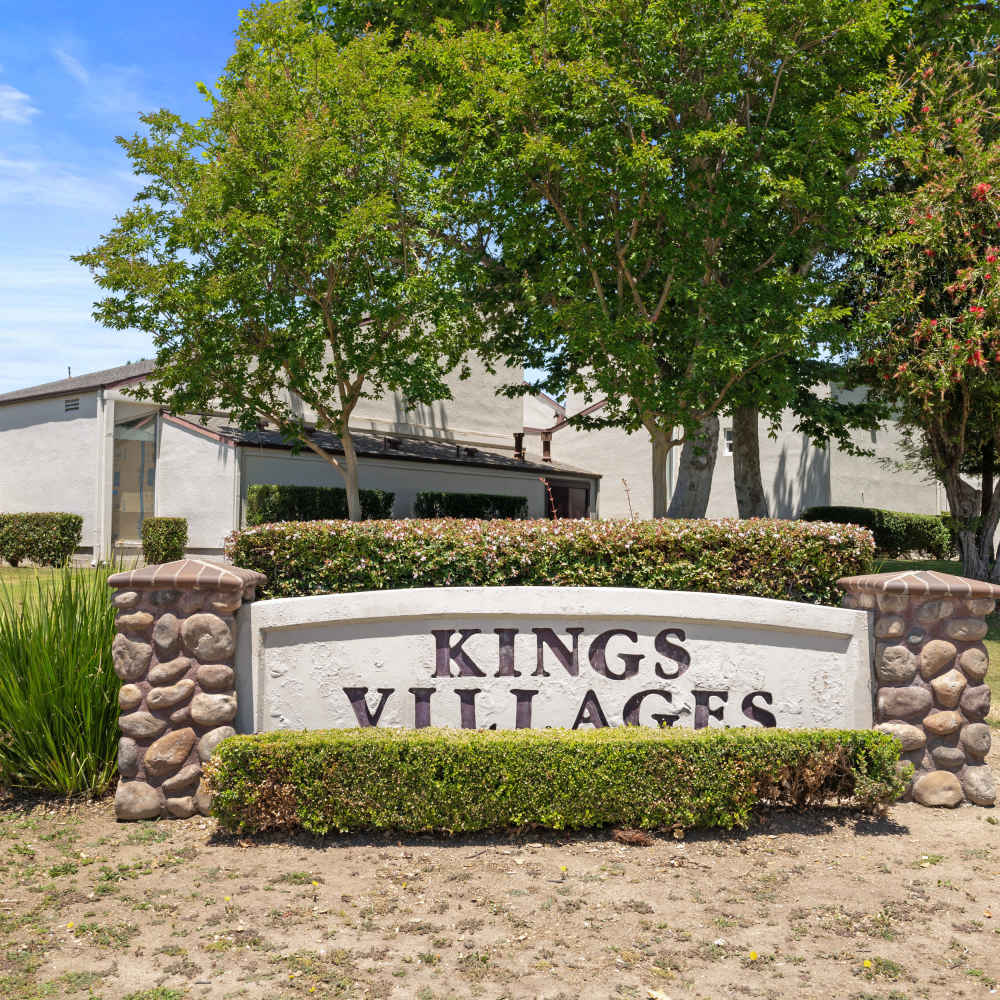 ground sign surrounded by lush greenery Kings Villages in Pasadena, California