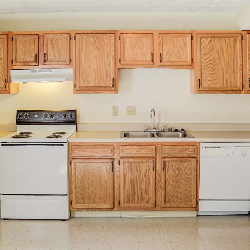 Bright kitchen with oak cabinets, white appliances, and ample counter space at Arlington Greene in London, Kentucky