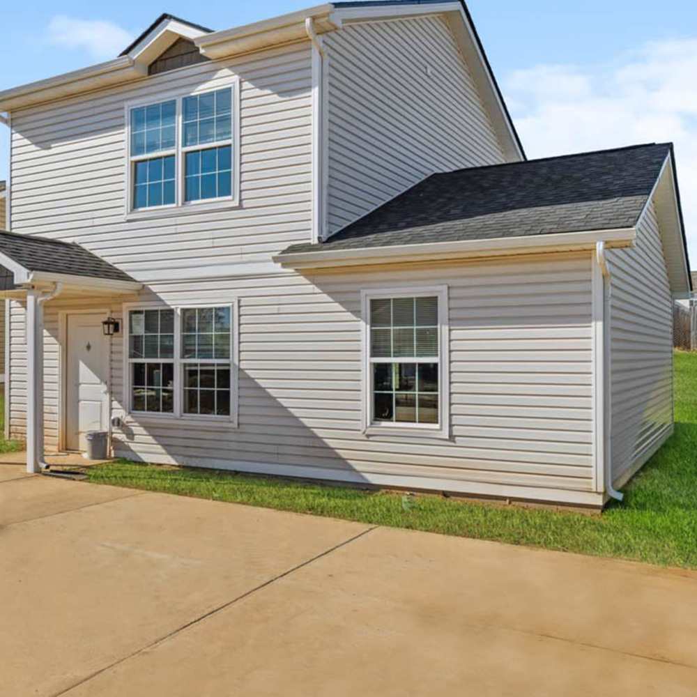 Two-story apartment exterior with large windows and grassy area at Woodbury Crossing in Corryton, Tennessee