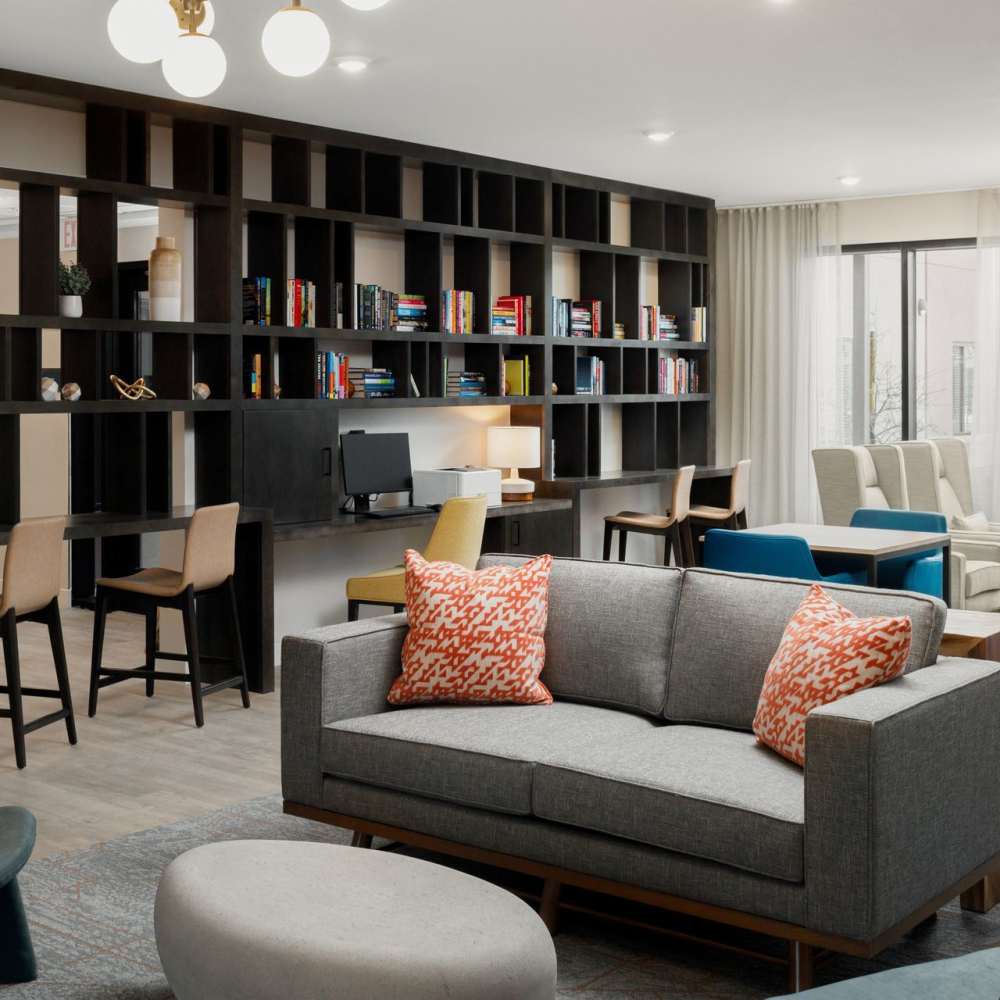 Resident lounge with seating, workspace, and built-in shelving at Waterwalk Tucson in Tucson, Arizona