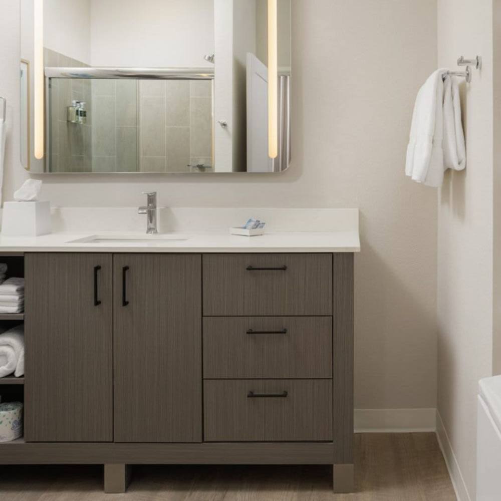Bathroom with vanity, storage cabinets, and large mirror at Waterwalk Tucson in Tucson, Arizona