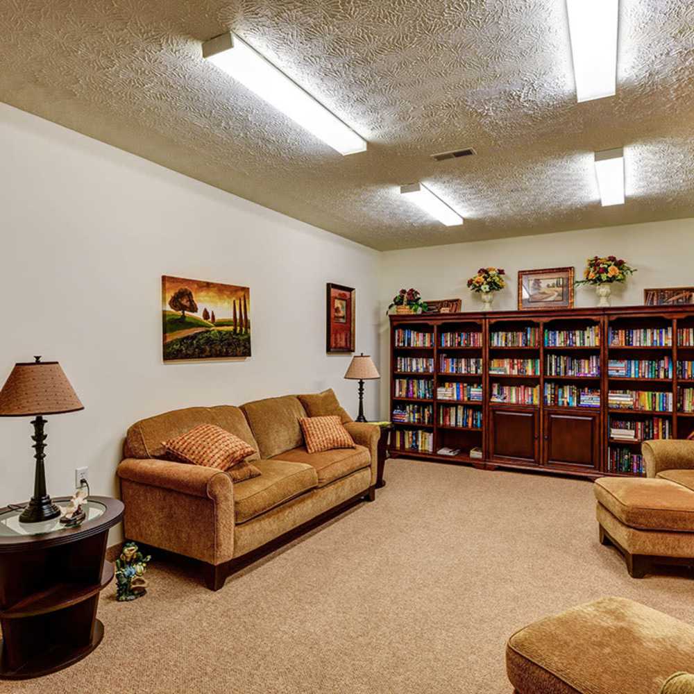 Cozy carpeted lounge with bookshelves at Beaumont Greene Senior Living in Athens, Ohio