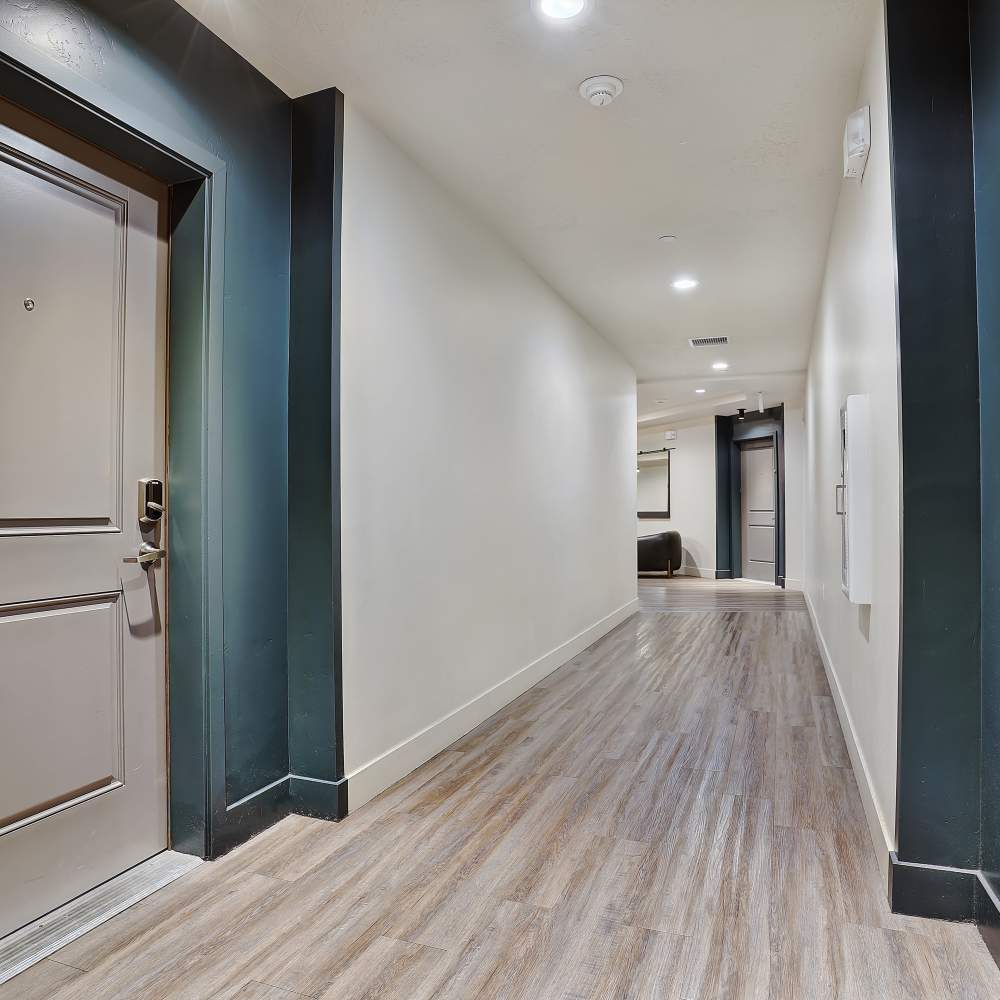 Modern hallway with wood-style flooring and a welcoming entrance door at Canyon View Crossing in Orem, Utah