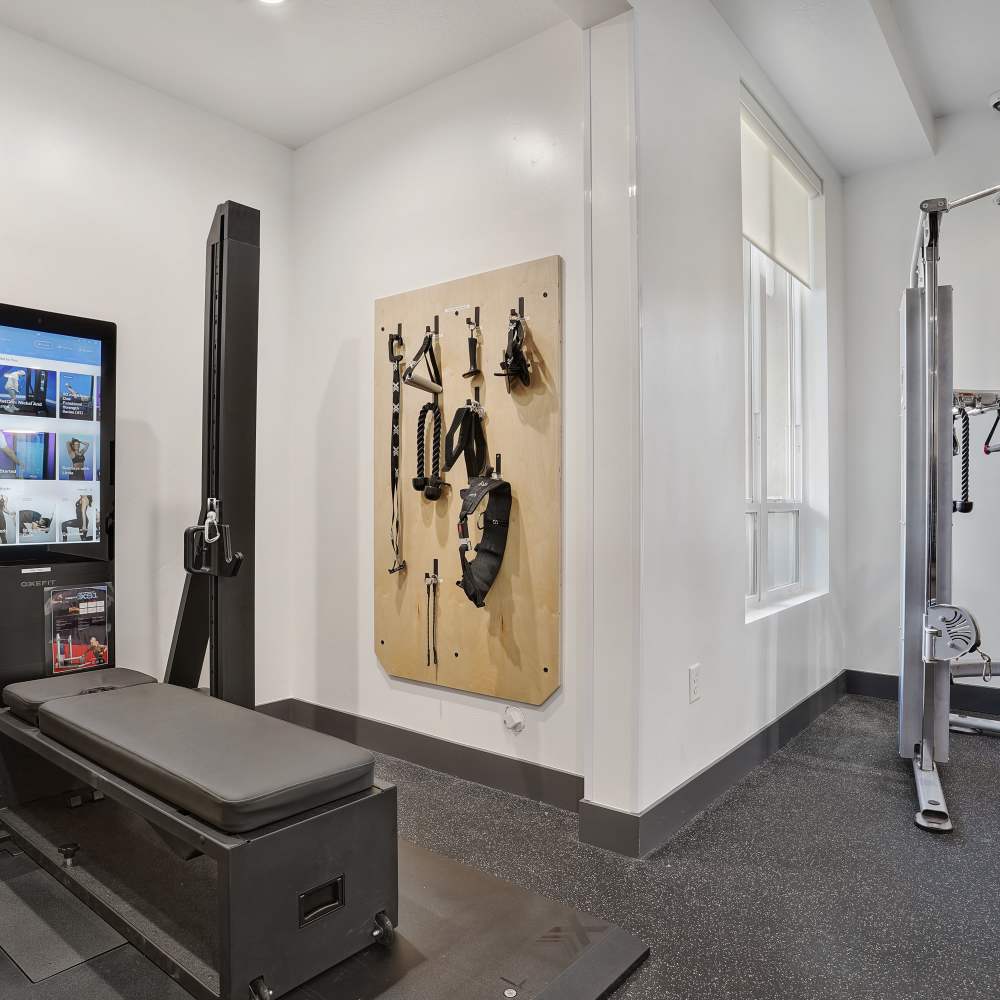 Modern fitness center with workout equipment and wall-mounted accessories for strength training at Canyon View Crossing in Orem, Utah