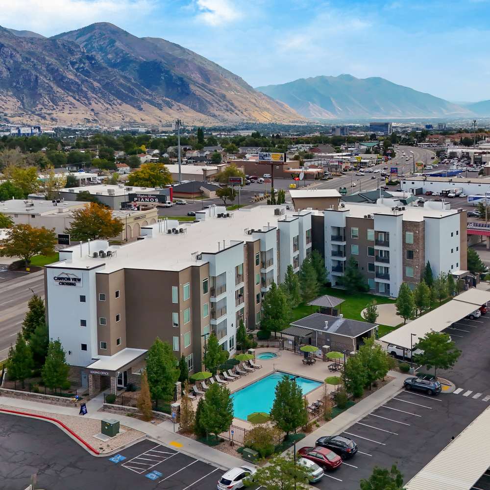 Aerial view of apartment community with resort-style pool and landscaped grounds at Canyon View Crossing in Orem, Utah