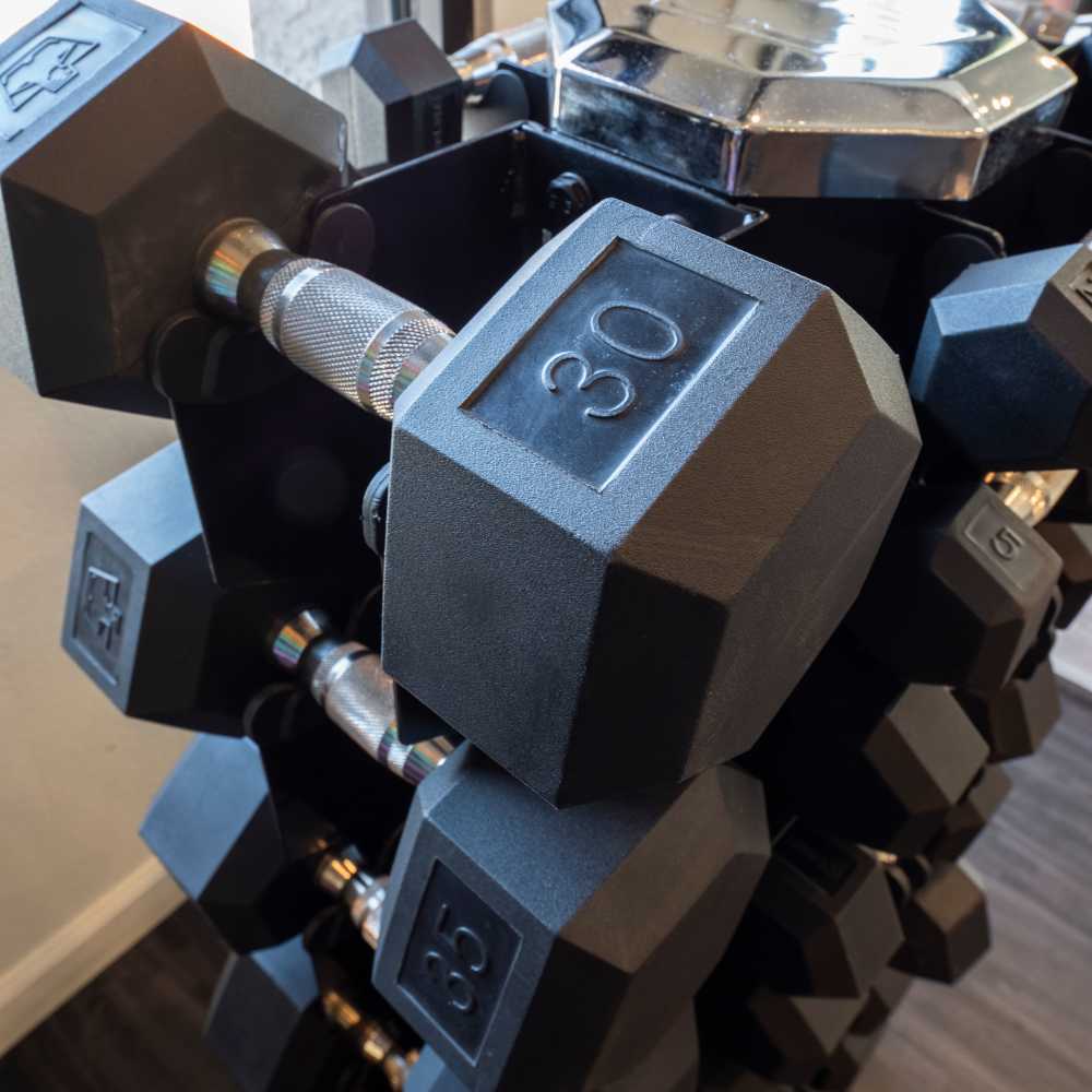 Dumbbell rack with various weights in a fitness center with wood-style flooring at Fairways on Thunderbird in Phoenix, Arizona