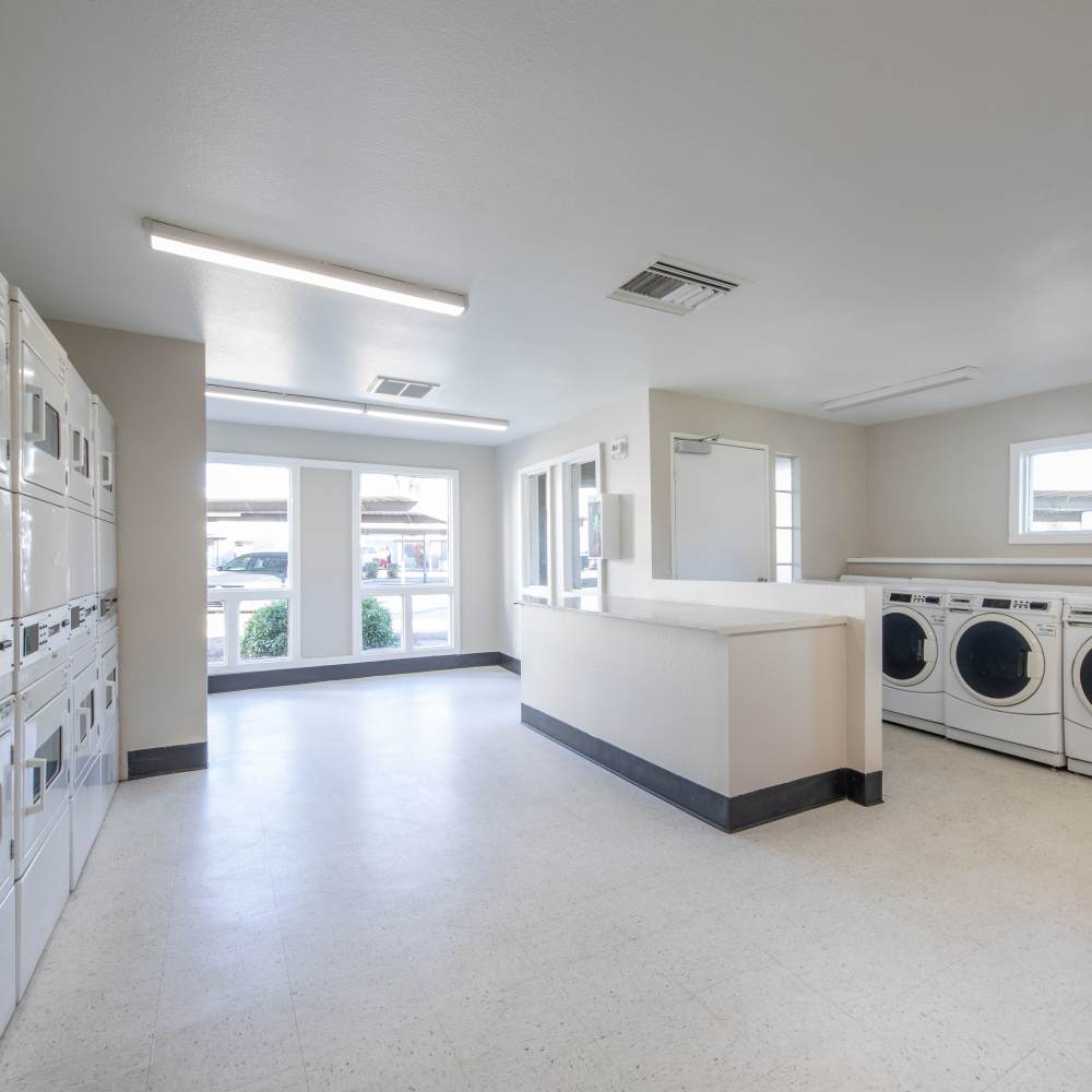 Bright laundry room with modern machines, large windows, and clean, open layout at Fairways on Thunderbird in Phoenix, Arizona