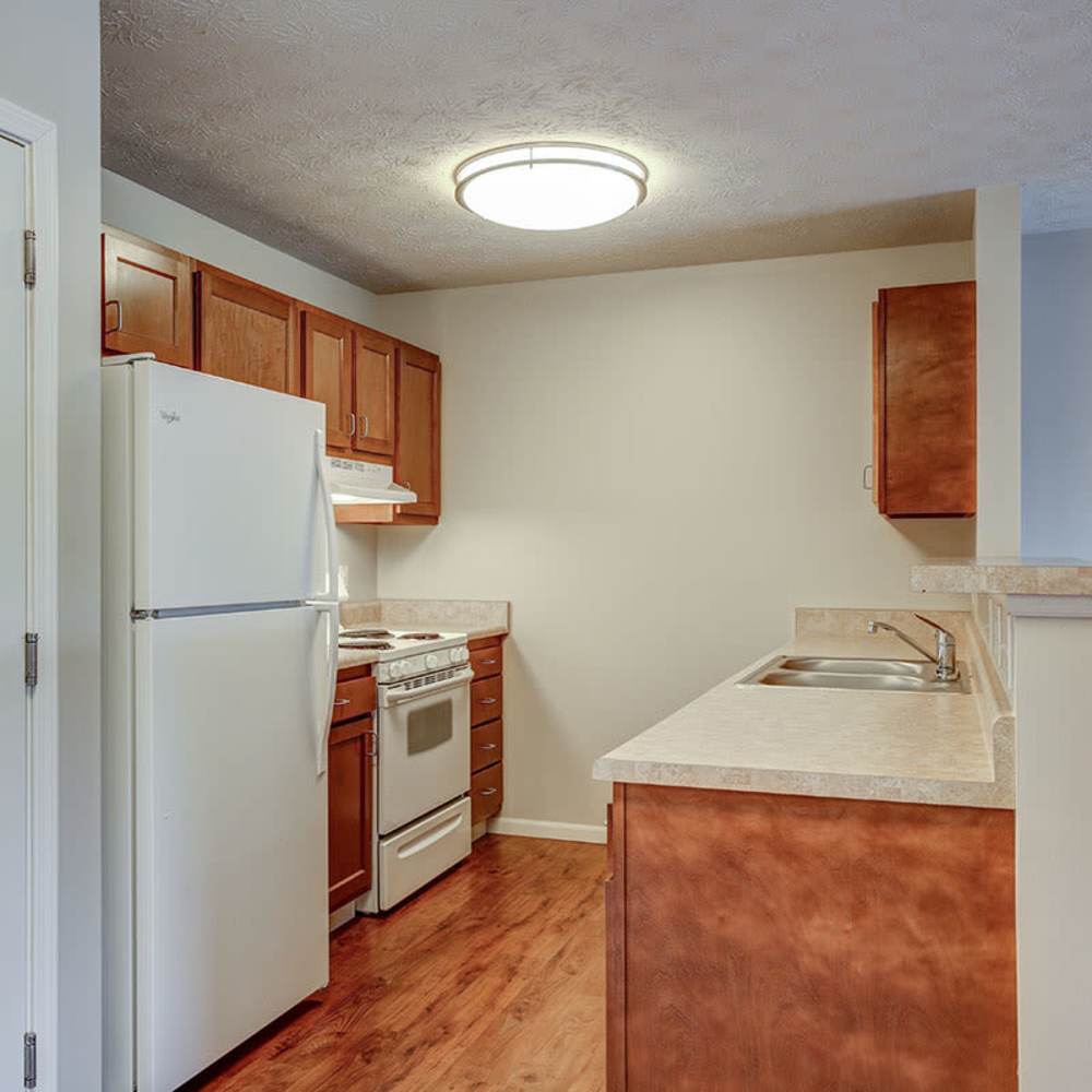 Open layout kitchen with wood-style flooring at Meridian Greene I in Wintersville, Ohio