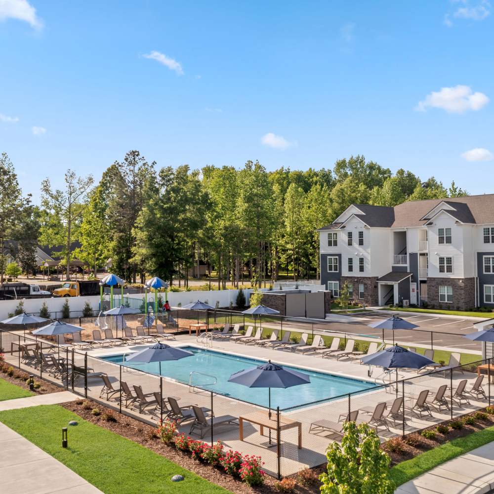 Swimming pool with sun decks and umbrellas at The Warwick at Foundry Creek in Richmond, Virginia