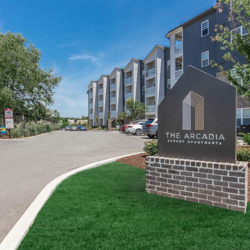 Gated entrance to luxury apartment community with landscaped grounds and modern buildings at The Arcadia in Madison, Tennessee