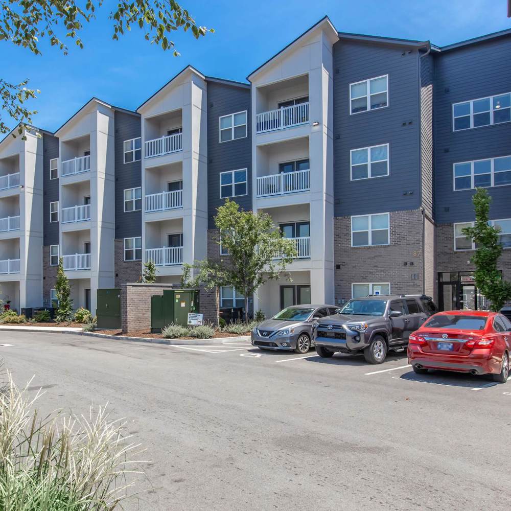 Modern apartment community with balconies, landscaped grounds, and parking spaces for residents at The Arcadia in Madison, Tennessee